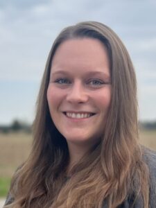 Heimatpflegerin Jette Weichselgartner. Frau in den dreißigern. Lange, dunkelblonde Haar, Blaue Augen.